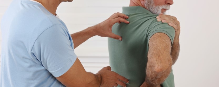 Chiropractor evaluating a patient with lower back pain during a clinical consultation